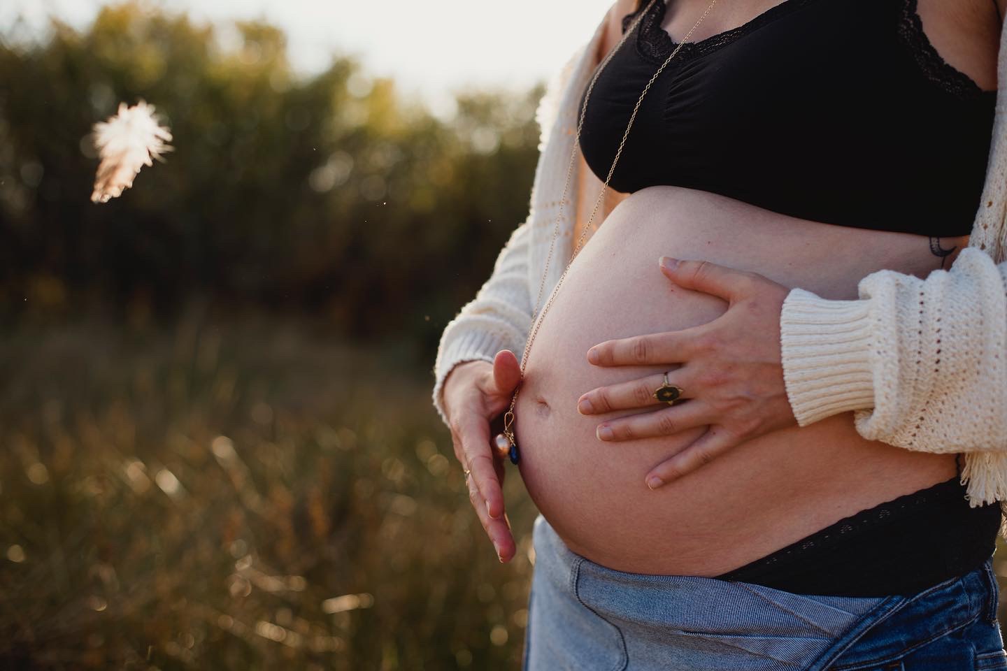 Gros ventre de femme enceinte à terme avec une plume et un bola Crédits photo : Céline Caudal